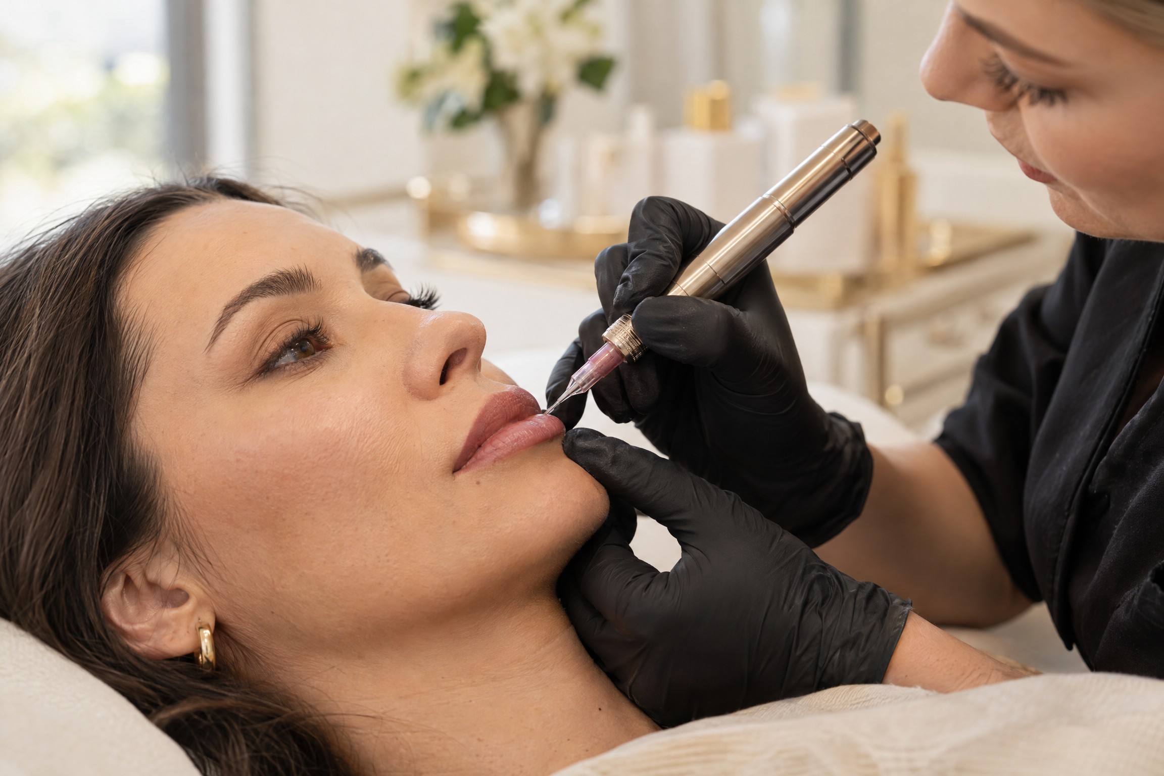 A client receives a permanent makeup lip-blush treatment